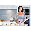 Beautiful woman holding glass with red wine in her kitchen