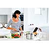 Image of beautiful woman standing in the kitchen and cooking