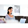 Beautiful woman sitting at home and working on her laptop