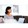 Beautiful woman sitting at home and working on her laptop