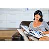 Happy woman reading book sitting on a sofa in the living room at home