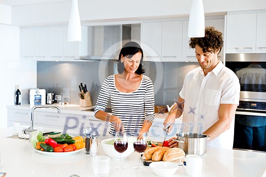 Couple cooking together in the modern kitchen at home Couple cooking together in the modern kitchen at home