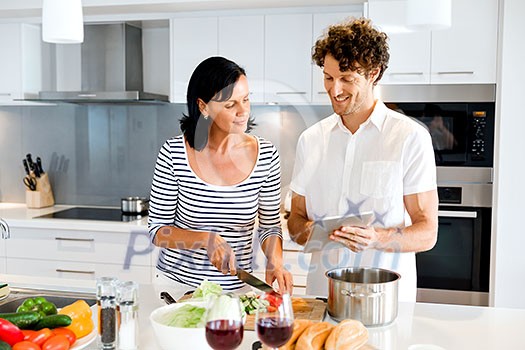 Couple cooking together in the modern kitchen at home Couple cooking together in the modern kitchen at home
