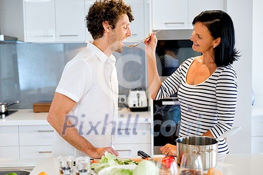 Couple cooking together in the modern kitchen at home Couple cooking together in the modern kitchen at home