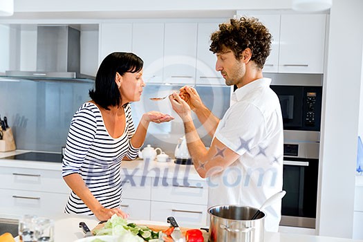 Couple cooking together in the modern kitchen at home Couple cooking together in the modern kitchen at home