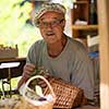 senior man gardener herbalist picking gathering fresh herbs for alternative medicine tea and poutting on balance