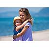 Happy smiling little sisters having fun while hugging on the beach coast during Summer vacation  Healthy childhood lifestyle concept