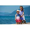 Happy smiling little sisters having fun holding their hands while walking on the beach coast during Summer vacation  Healthy childhood lifestyle concept