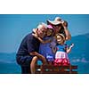 portrait of  happy grandparents with cute little granddaughters having fun on a bench by the sea during Summer vacation  Healthy family holiday concept