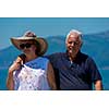 happy romantic senior couple hugging while walking  by the sea during Summer vacation