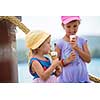 adorable little girls eating ice cream on beach by the sea during Summer vacation