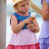 adorable little girls eating ice cream on beach by the sea during Summer vacation