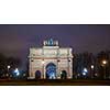 Paris, France - August 04, 2006: Night panorama of the Triumphal arch du Carrousel on the background of the Ferris wheel and luminous street lamps