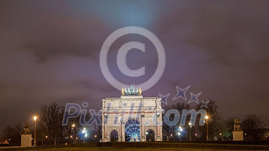 Paris, France - August 04, 2006: Beautiful view of the Arc de Triomphe du Carrousel in the evening against the backdrop of street lamps. Paris, France - August 04, 2006: Beautiful view of the Arc de Triomphe du Carrousel in the evening against the backdrop of street lamps.