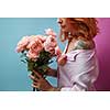 Pretty woman with tattoo holding bouquet of pink bouquet around a double blue pink background with copy space. St. Valentine's Day