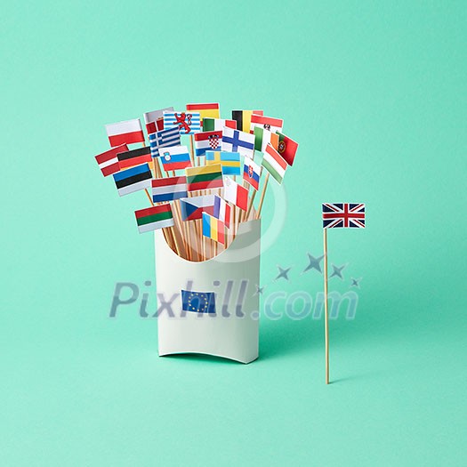 Different paper flags in a cardboard box with an EU sign and the flag of Britain aside on a green background . The exit of Britain from the EU Different paper flags in a cardboard box with an EU sign and the flag of Britain aside on a green background . The exit of Britain from the EU