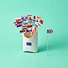 Different paper flags in a cardboard box with an EU sign and the flag of Britain aside on a green background . The exit of Britain from the EU