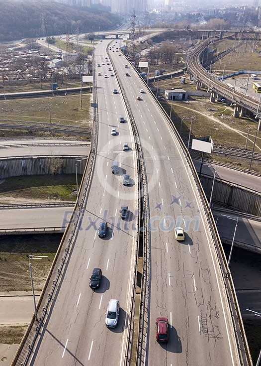 Bird's eye view from drone of speedway asphalt road, moving fast cars and tracks in a spring sunny day in city Kiev, Ukraine. Bird's eye view from drone of speedway asphalt road, moving fast cars and tracks in a spring sunny day in city Kiev, Ukraine.