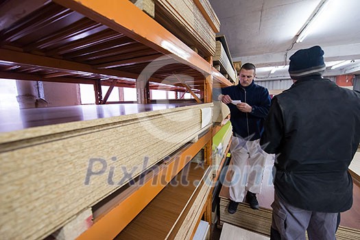 two young carpenters working together in big modern carpentry High quality wood concept two young carpenters working together in big modern carpentry High quality wood concept