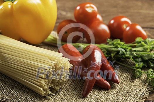 Pasta spaghetti vegetables spices and oil on table Pasta spaghetti vegetables spices and oil on table