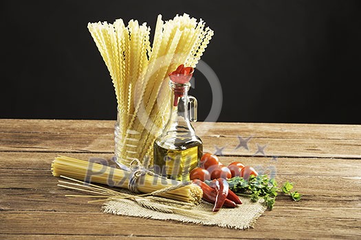 Pasta spaghetti vegetables spices and oil on table Pasta spaghetti vegetables spices and oil on table