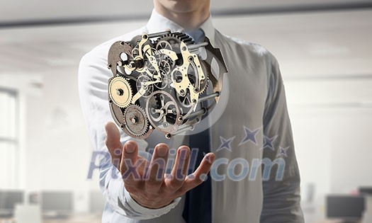 Metal gear mechanism in palm. Mixed media Metal gear mechanism in palm. Mixed media