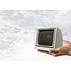 Old fashioned tube TV in human palm. Mixed media