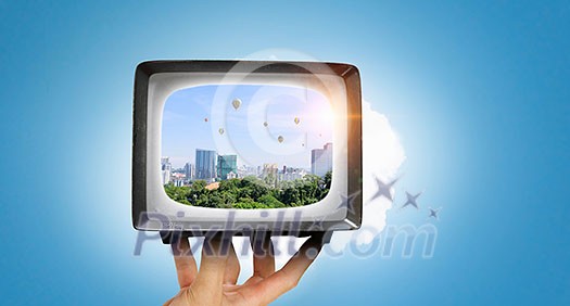 Old fashioned tube TV in human palm. Mixed media Old fashioned tube TV in human palm. Mixed media