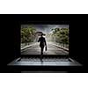 Small businessman with umbrella walking in to laptop screen. Mixed media
