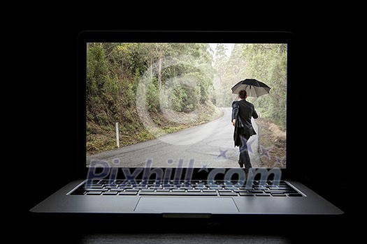 Small businessman with umbrella walking in to laptop screen. Mixed media Small businessman with umbrella walking in to laptop screen. Mixed media