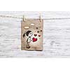 Paper sheet hanging on rope against wooden surface. Mixed media