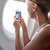 Young woman taking photos during flight in a modern airplane