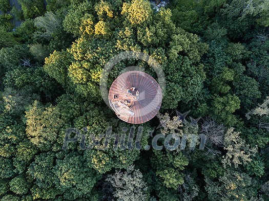 Aerial view of the drone on the greenery of trees and the old round roof with people summer day