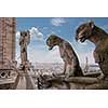 Stone demons gargoyle and chimera with Paris city on background. View from Notre Dame de Paris