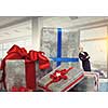 Young businesswoman among pile of gift boxes. Mixed media