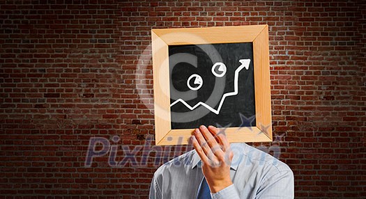 Handsome businessman holding wooden frame with business sketches. Mixed media Handsome businessman holding wooden frame with business sketches. Mixed media