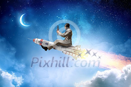 Funny piolot in helmet flying on missile rocket. Mixed media Funny piolot in helmet flying on missile rocket. Mixed media