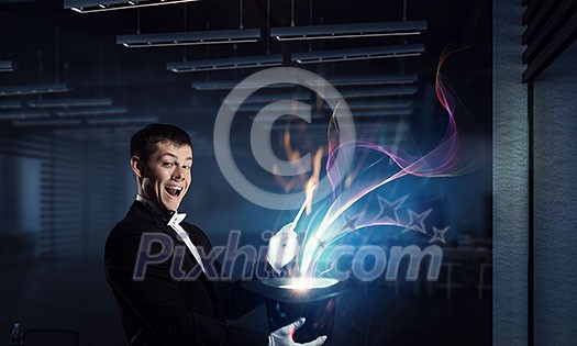Elegant businessman with hat and stick doing magic tricks. Mixed media Elegant businessman with hat and stick doing magic tricks. Mixed media