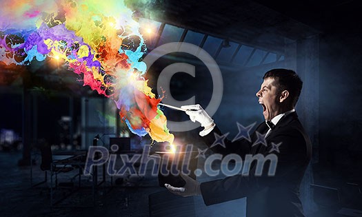 Elegant businessman with hat and stick doing magic tricks. Mixed media Elegant businessman with hat and stick doing magic tricks. Mixed media