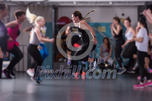 group of young healthy sporty women working out with instructor doing aerobics exercises in a fitness studio fitness, sport, training, gym and lifestyle concept