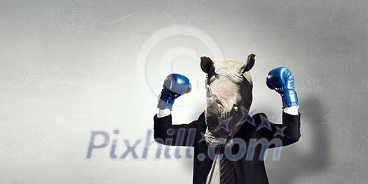Businessman in boxing glove with rhino head. Mixed media