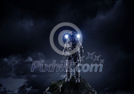 Space explorer in astronaut suit at rock top. Mixed media Space explorer in astronaut suit at rock top. Mixed media