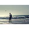 Young relaxed businessman at seaside talking mobile and looking far away at sea. Mixed media