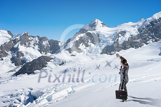 Businessman in suit among snowy mountains ready to overcome any challenge. Mixed media Businessman in suit among snowy mountains ready to overcome any challenge. Mixed media