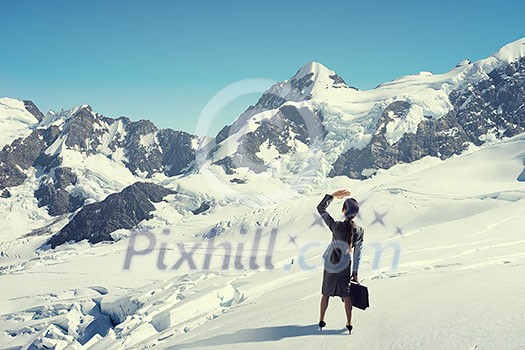 Businesswoman in suit among snowy mountains ready to overcome any challenge. Mixed media Businesswoman in suit among snowy mountains ready to overcome any challenge. Mixed media