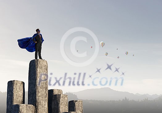 Super businessman on top of stone column. Mixed media Super businessman on top of stone column. Mixed media