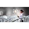 Attractive scientist woman with tablet pc in dark lab. Mixed media