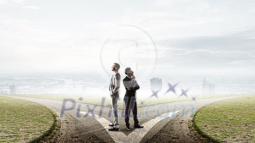 Two businessmen standing back to back and looking away. Mixed media Two businessmen standing back to back and looking away. Mixed media