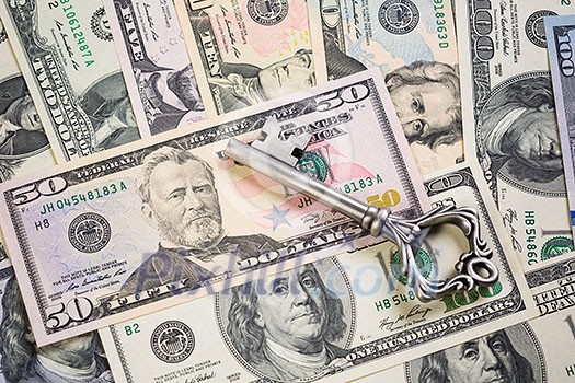 A lot of dollar banknotes and old key A lot of dollar banknotes and old key