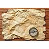 Old crumpled paper and compass on wooden table